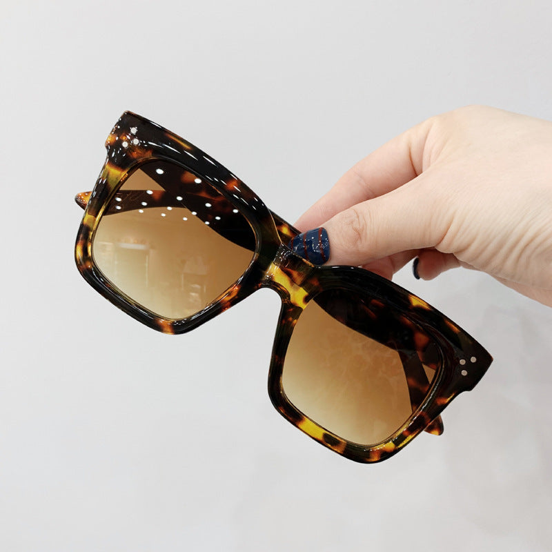 Retro square UV400 sunglasses by RAMODO JEWELRY with black frames and tinted lenses.