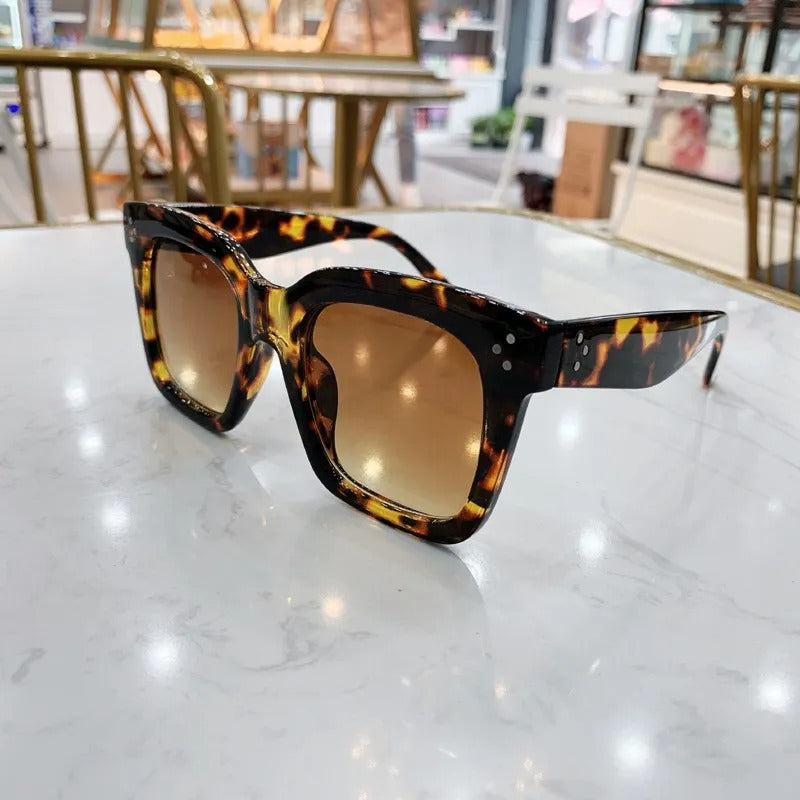 Retro square UV400 sunglasses by RAMODO JEWELRY with black frames and tinted lenses on a white background.