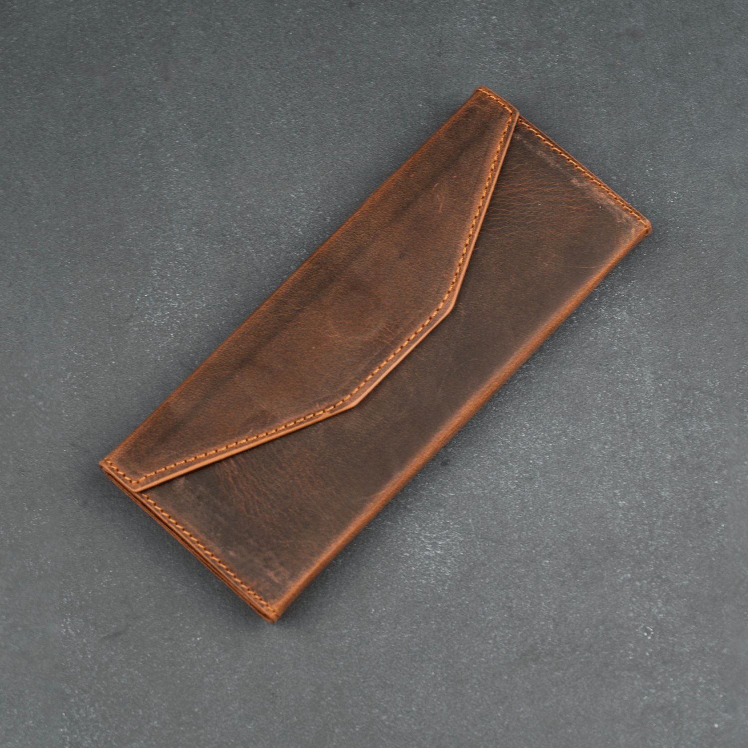 Dark brown leather sunglasses case by LEATHERE, luxury eyewear accessory, designed to protect and store sunglasses.