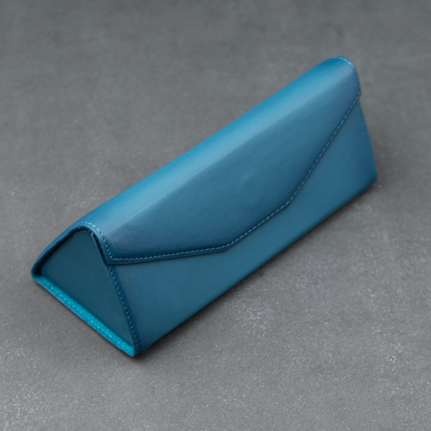 Dark blue luxury leather sunglasses case by LEATHERE, designed for stylish eyewear protection.