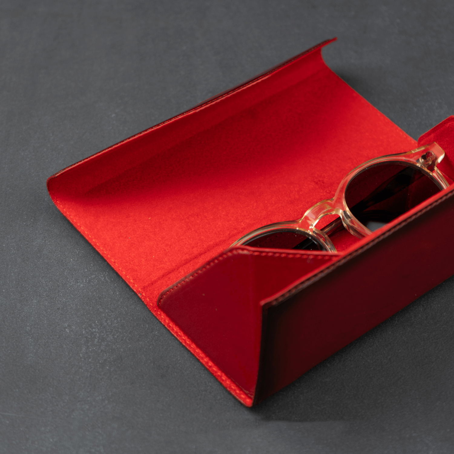 Red luxury leather sunglasses case by LEATHERE, designed for eyewear accessories, with a sleek and stylish appearance.
