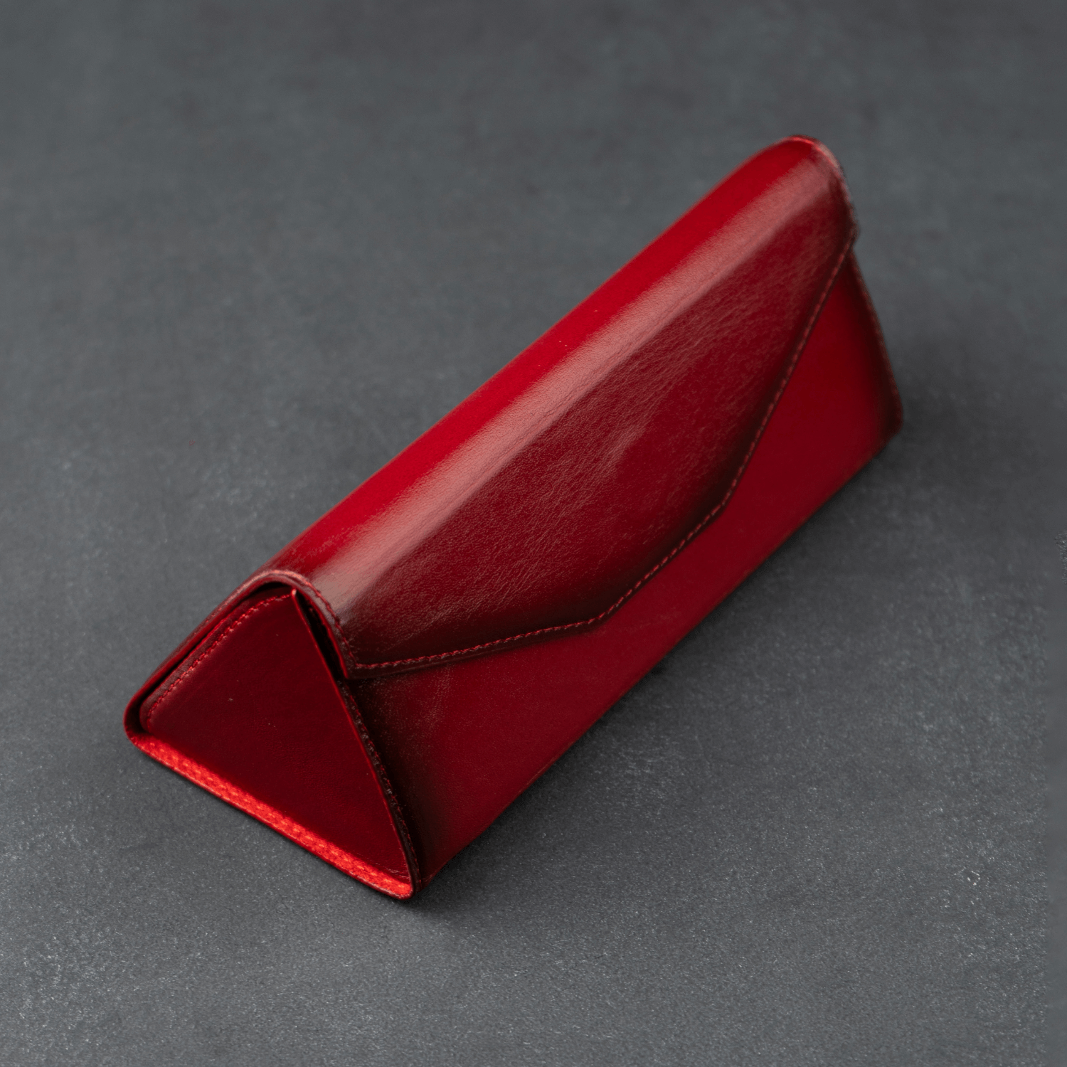 Red luxury leather sunglasses case by LEATHERE, designed for eyewear accessories, with a sleek and stylish appearance.
