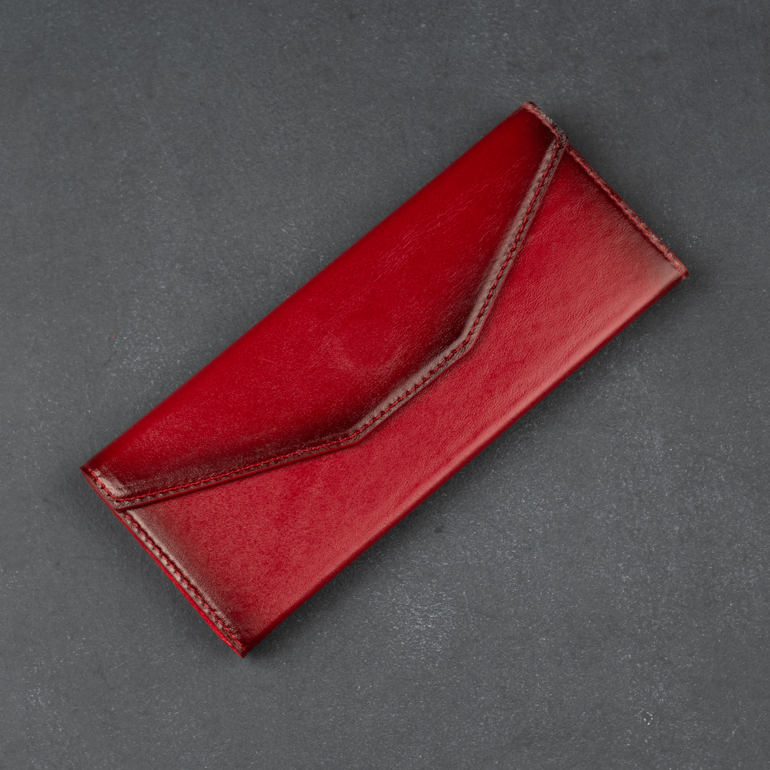 Red luxury leather sunglasses case by LEATHERE, stylish eyewear accessory for protecting and storing sunglasses.