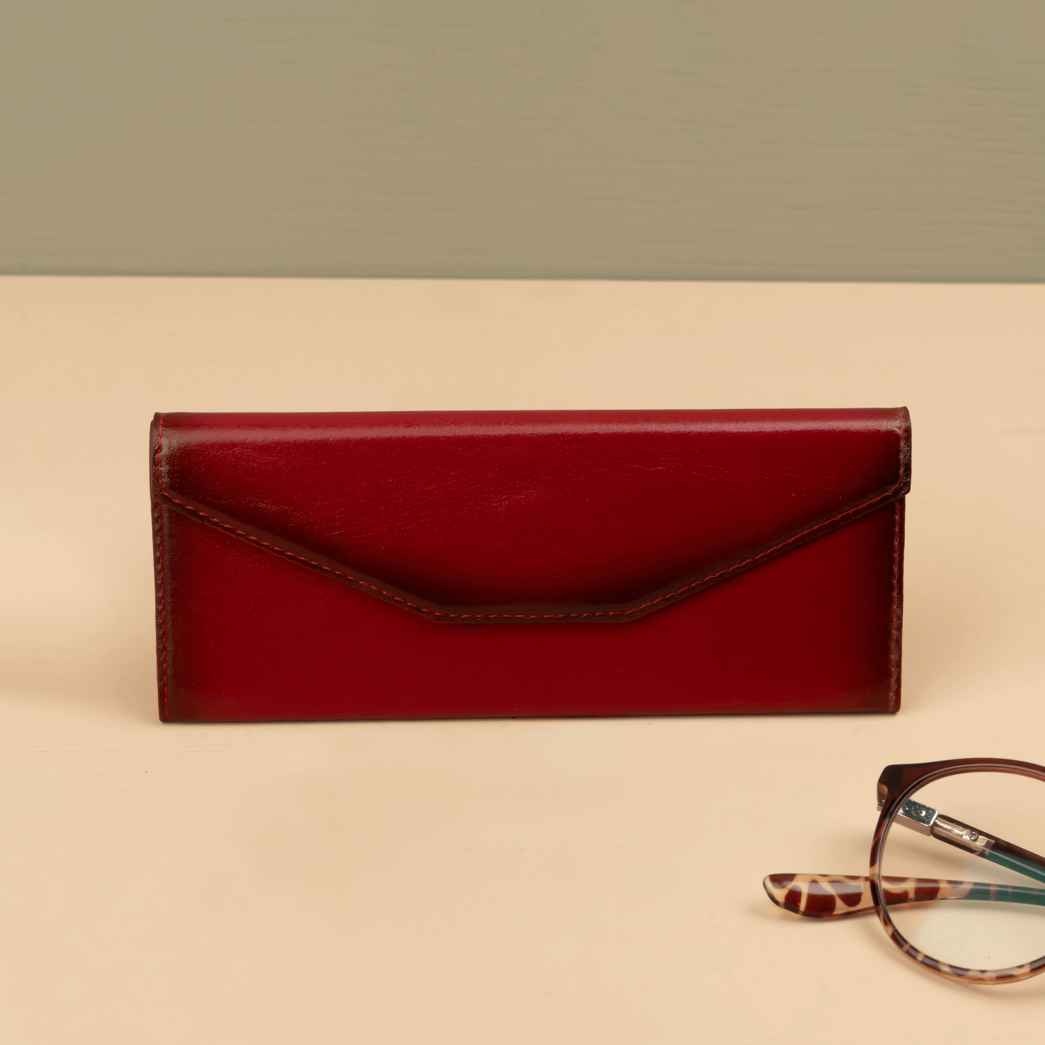 Red luxury leather sunglasses case from LEATHERE, designed for eyewear accessories, with a sleek and stylish appearance.