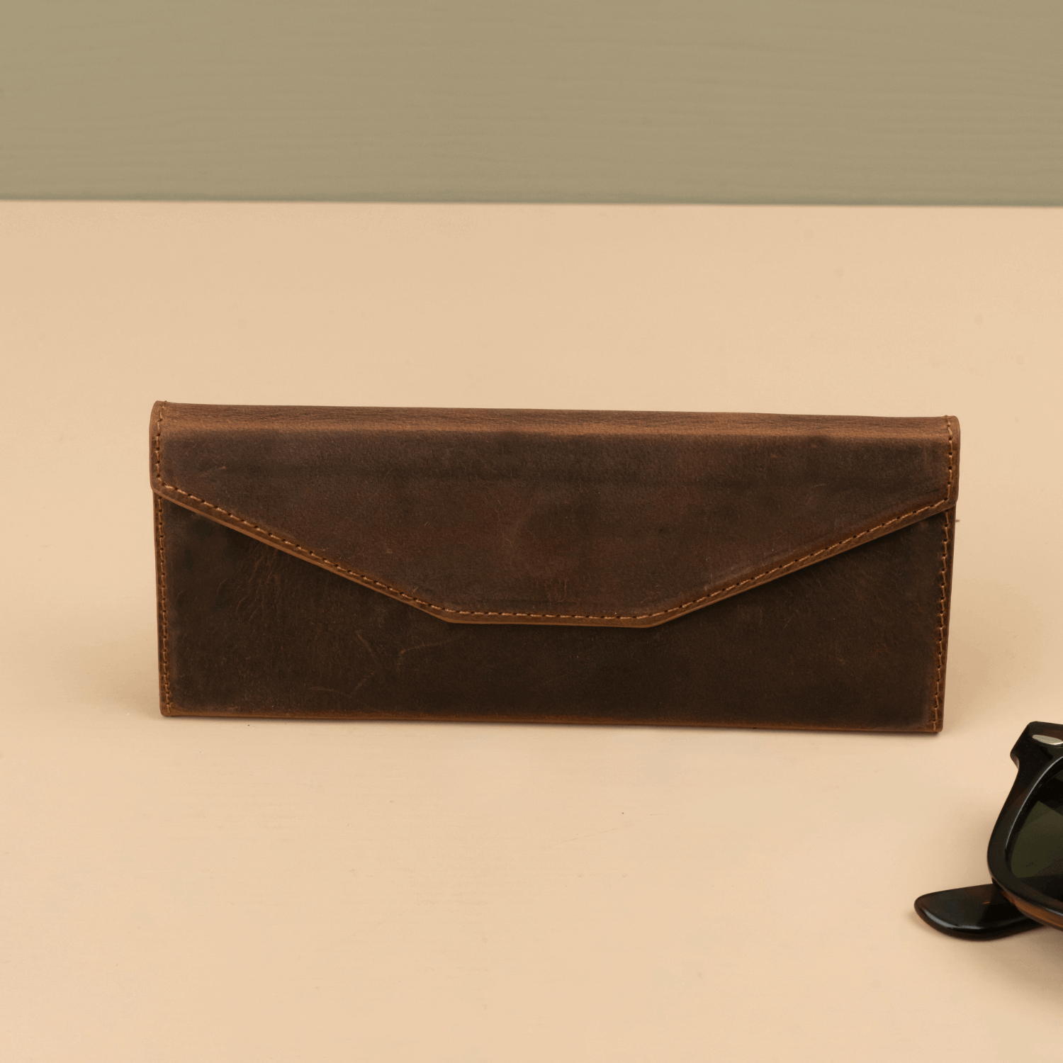 Dark brown luxury leather sunglasses case by LEATHERE, stylish eyewear accessory with a sleek, protective design.