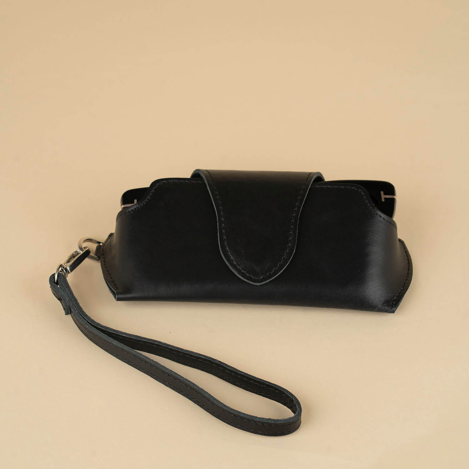 Black leather sunglass case with attached wrist strap by LEATHERE, designed for stylish eyewear protection and easy carrying.