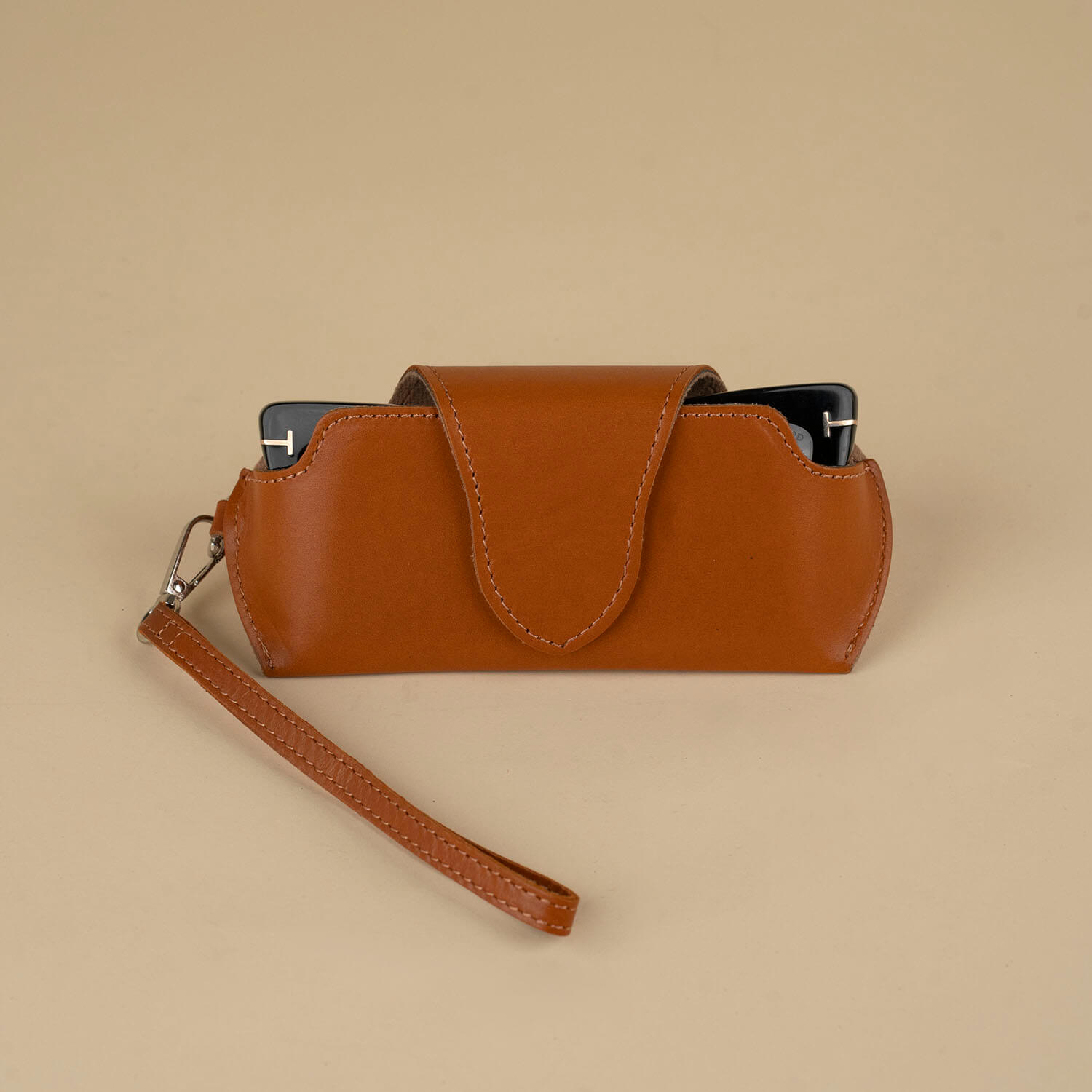 Medium brown leather sunglass case with wrist strap from LEATHERE, designed for eyewear accessories and protection.