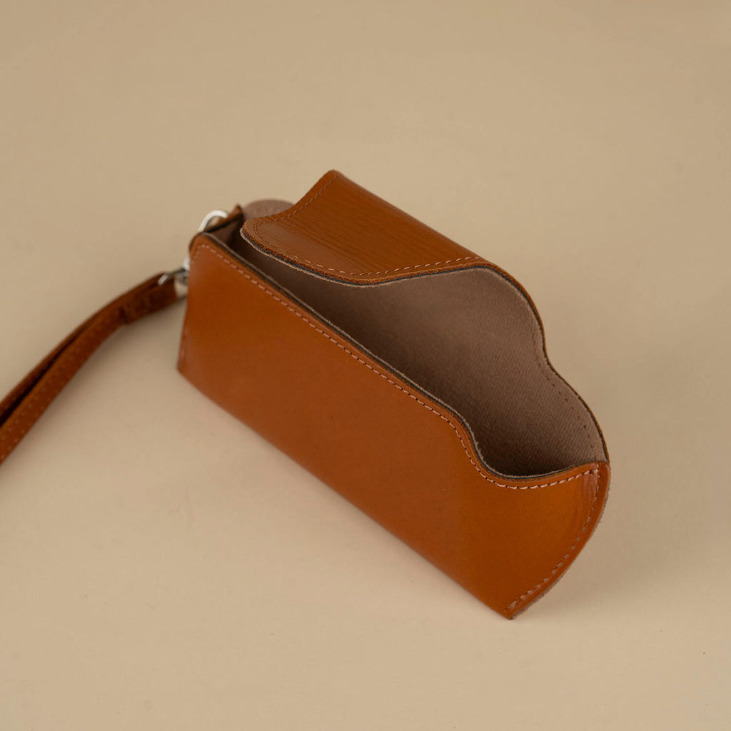 Medium brown leather sunglass case with wrist strap, designed for eyewear accessories by LEATHERE.