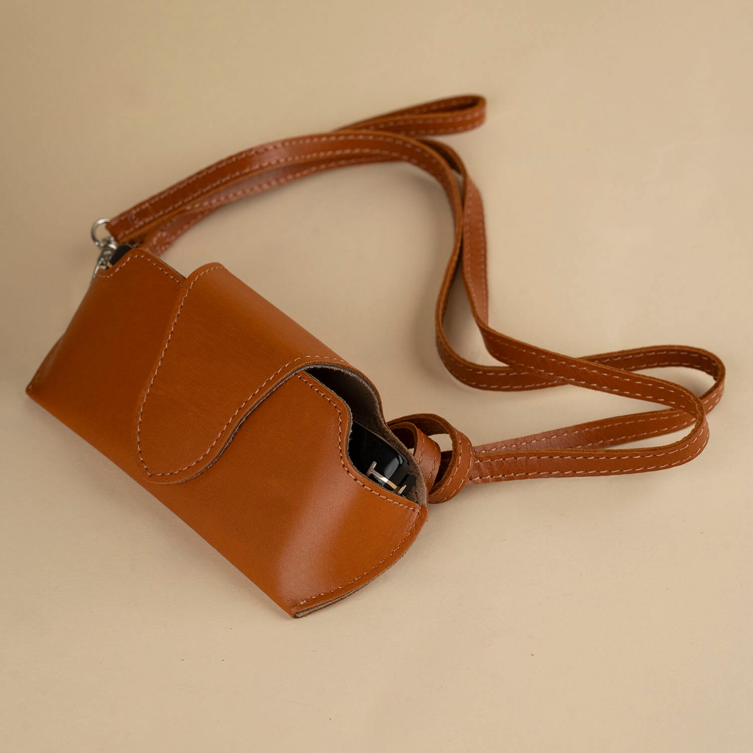 Medium brown leather sunglass case with wrist strap from LEATHERE, designed for eyewear protection and easy portability.