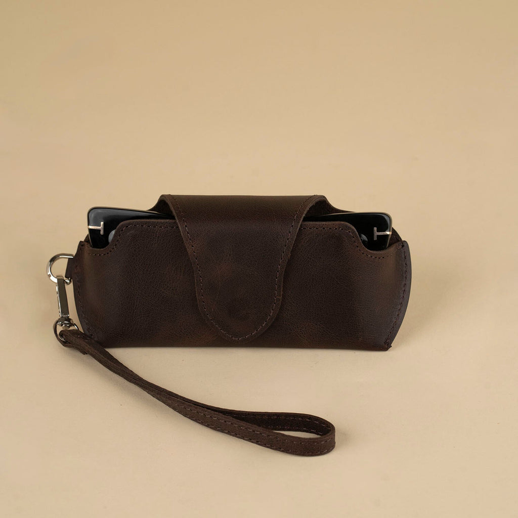Dark brown leather sunglass case with wrist strap from LEATHERE, designed for eyewear accessories.
