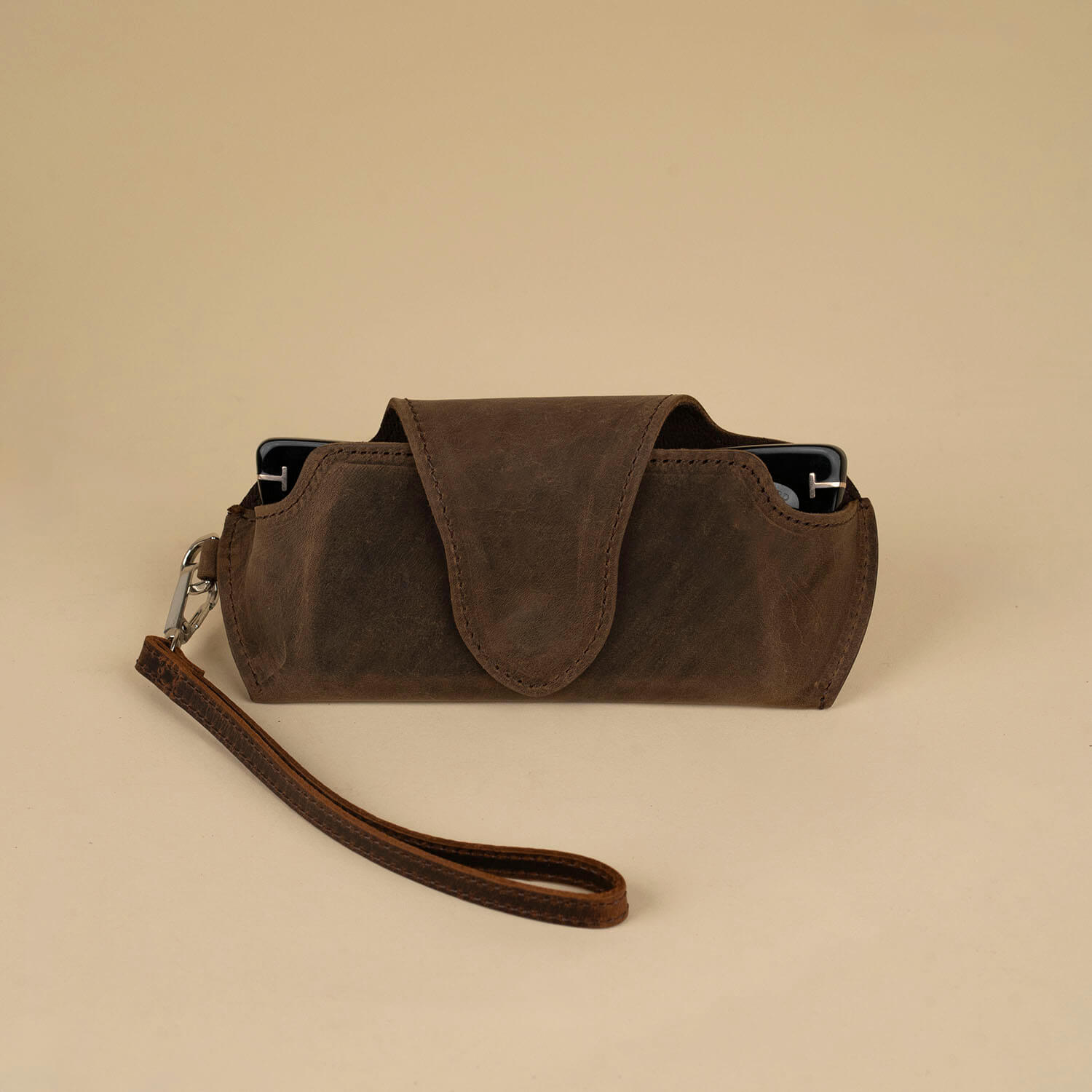 Rich dark brown leather sunglass case with attached wrist strap, designed by LEATHERE for stylish eyewear protection.