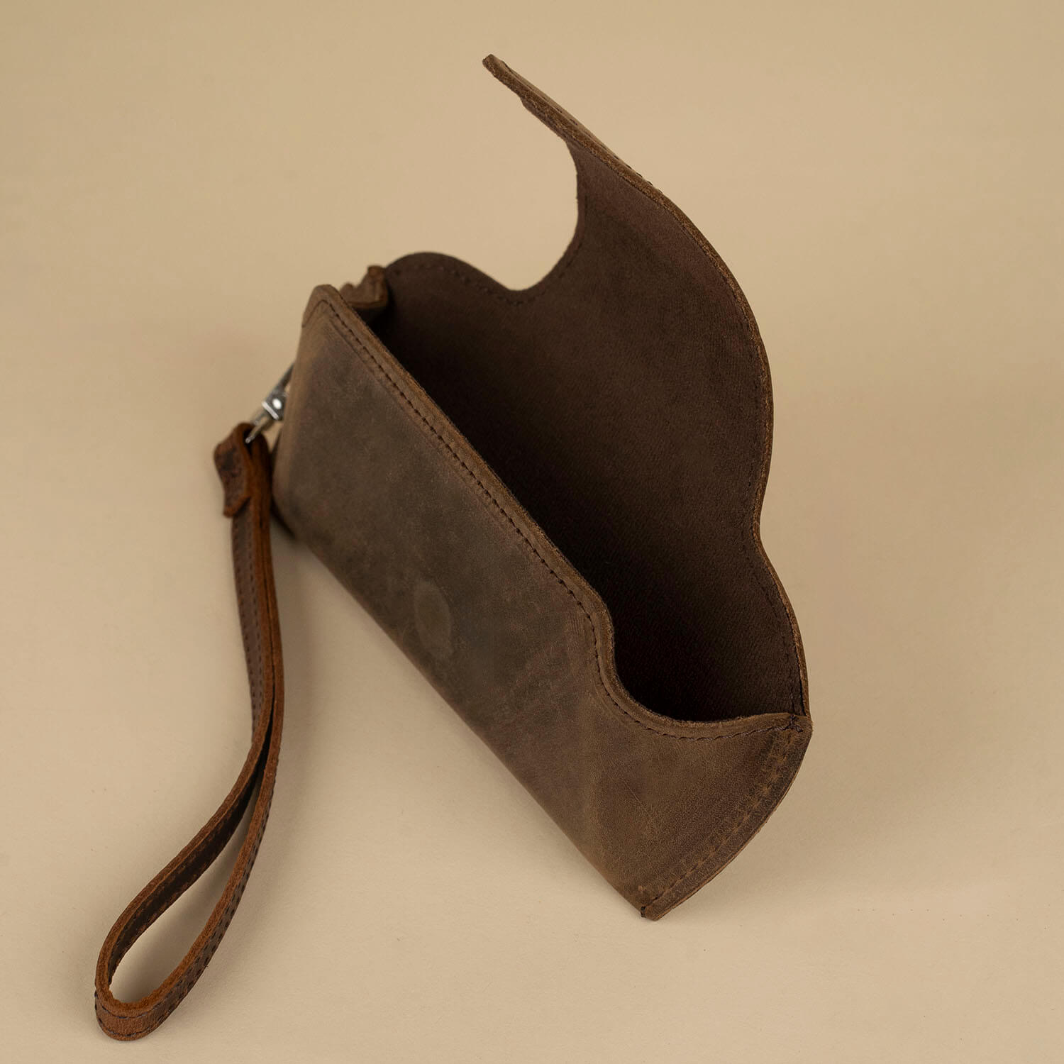 Rich dark brown leather sunglass case with wrist strap from LEATHERE, designed for stylish eyewear protection and easy carry.