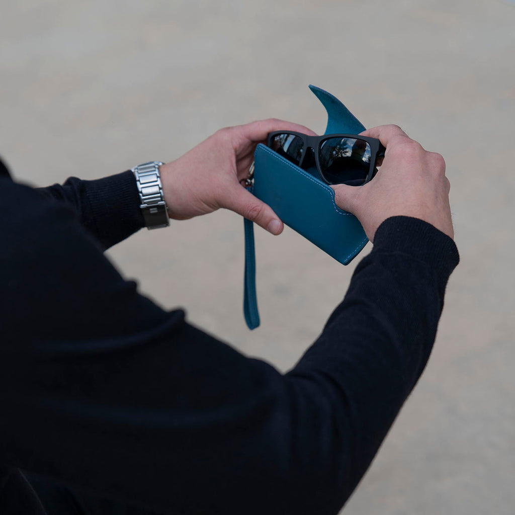 Navy blue leather sunglass case with wrist strap by LEATHERE, designed for eyewear protection and easy carrying.