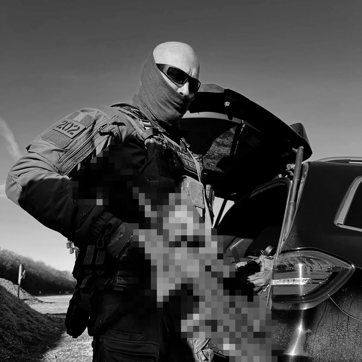 OutLaw Eyewear Fugitive TAC brushed gunmetal sunglasses with polarized lenses, worn by a man in a lifestyle setting.