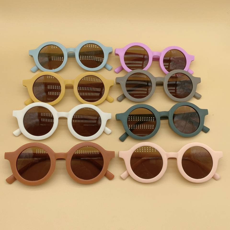 Vintage style kids sunglasses by ozznekshoes with round frames and tinted lenses, perfect for playful outdoor wear.