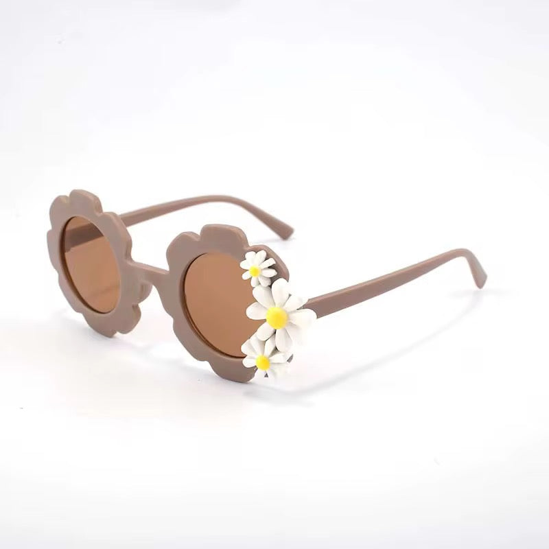 Kid's retro flower-shaped sunglasses with daisy design by ozznekshoes, featuring colorful frames and tinted lenses.