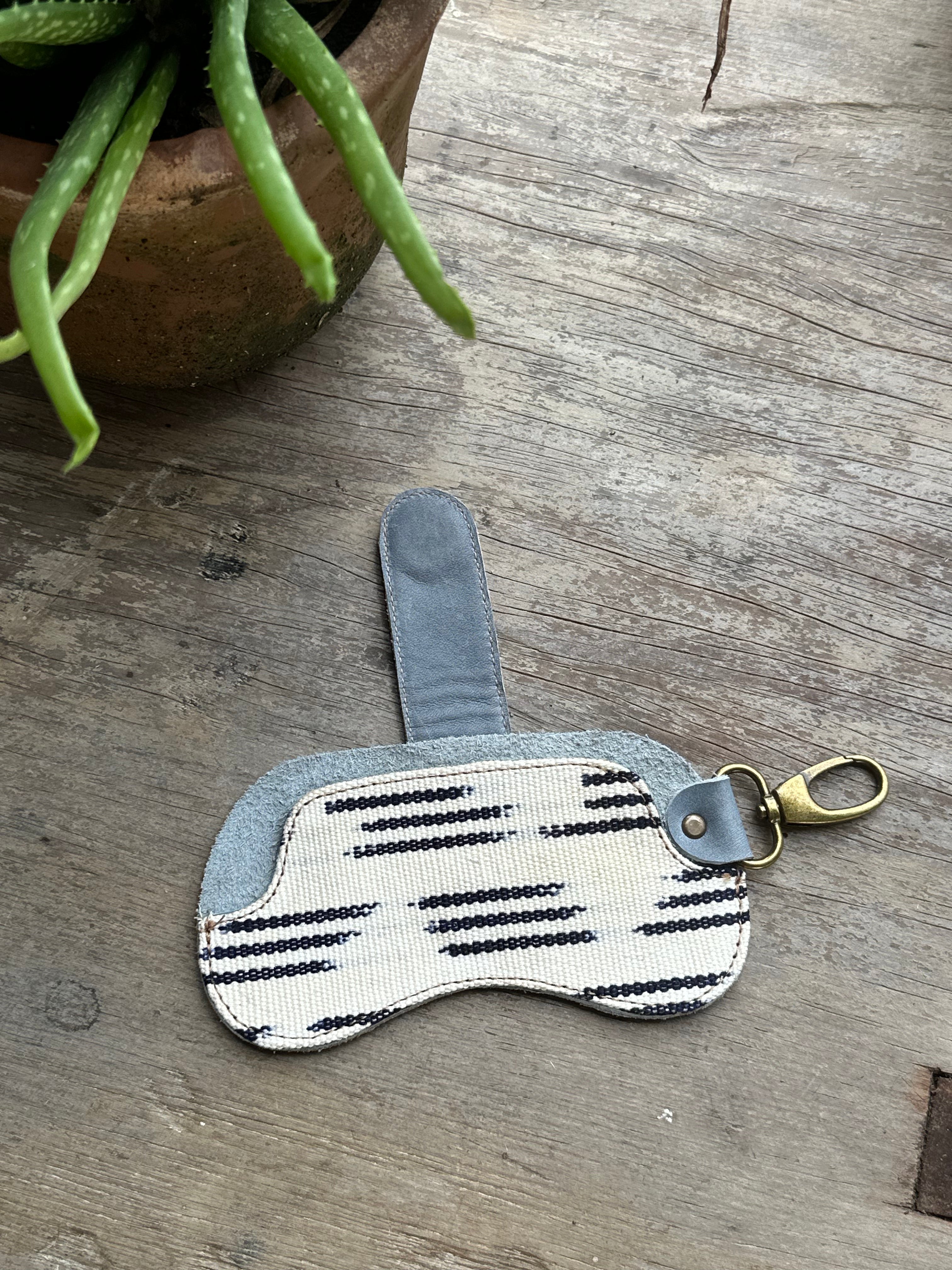 Black striped eyewear case from IXCHELTRIANGLE, designed for storing and protecting sunglasses.
