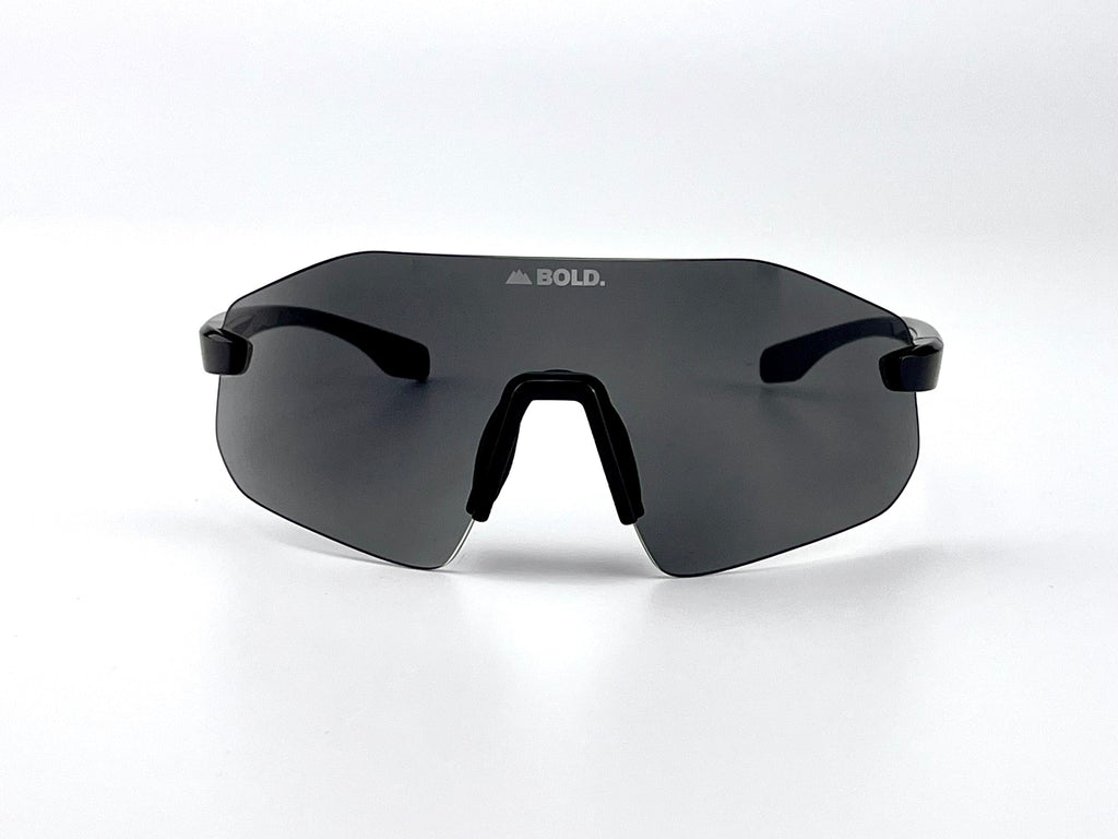 Boldouterwear BOLD Emerald photochromic sunglasses outdoors, showcasing stylish sunglasses with emerald frames and adaptive lenses.