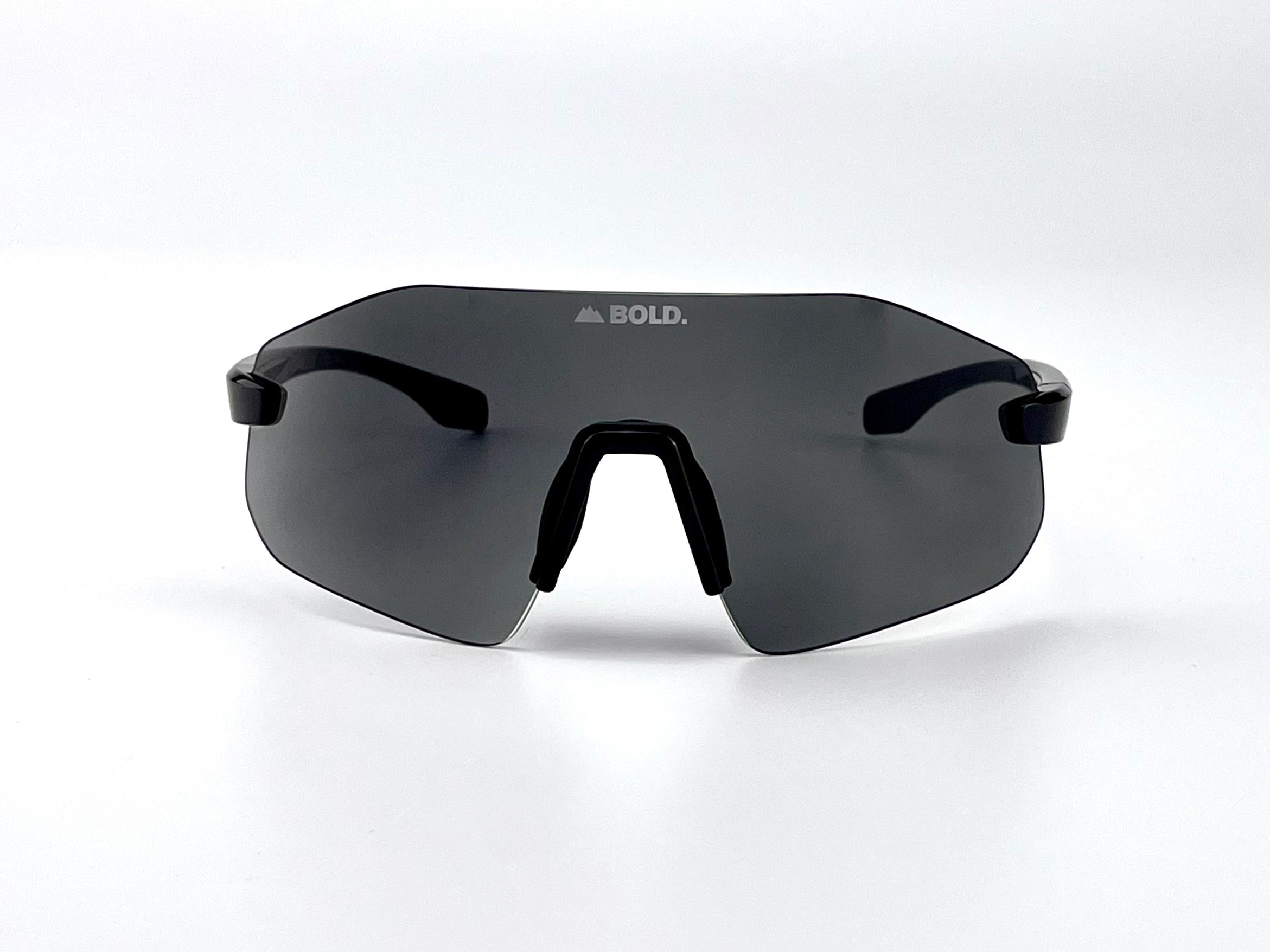 Boldouterwear BOLD Emerald photochromic sunglasses outdoors, showcasing stylish sunglasses with emerald frames and adaptive lenses.