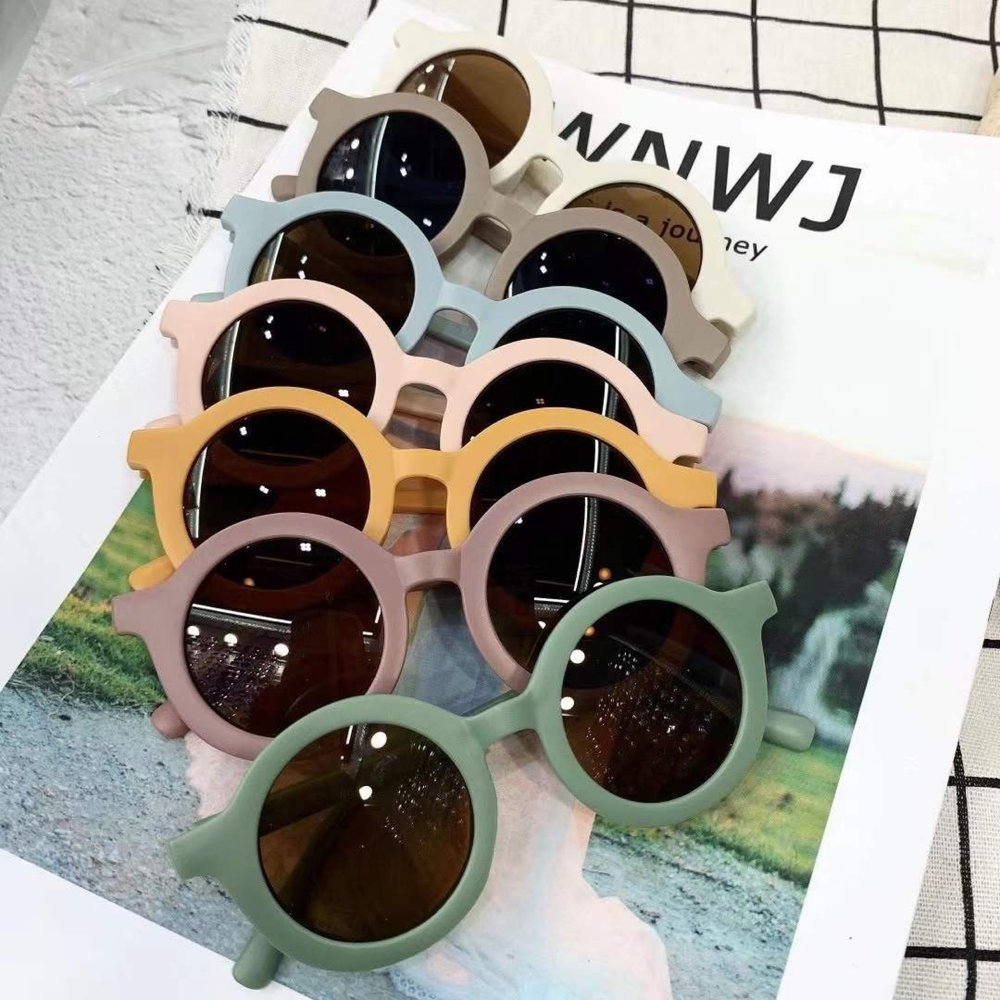 Round vintage style kids sunglasses by ozznekshoes with dark tinted lenses and colorful frame for playful eye protection.