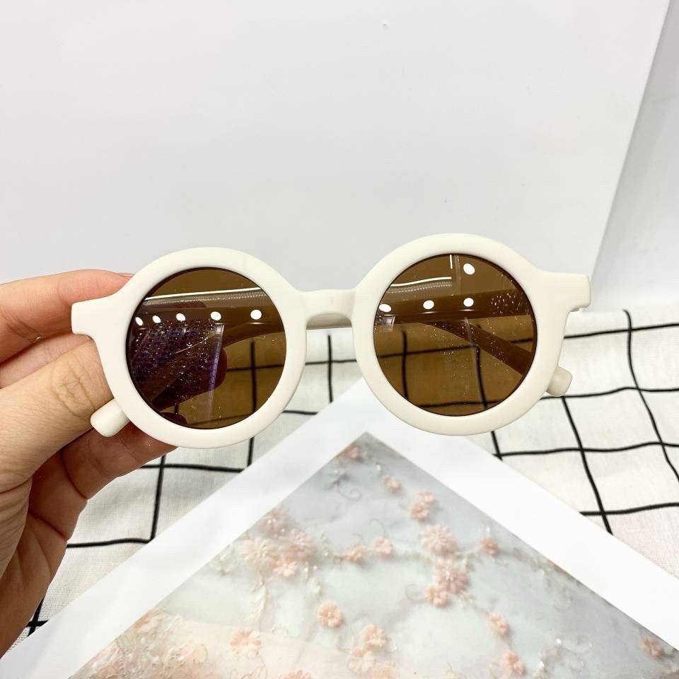 Round vintage style kids sunglasses with black frames and dark lenses, perfect for playful outdoor wear by ozznekshoes.