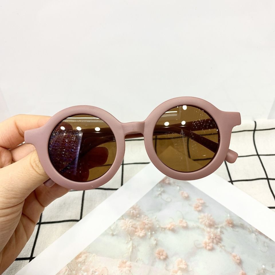 Round vintage style kids sunglasses with black frames and dark lenses, designed for children by ozznekshoes.