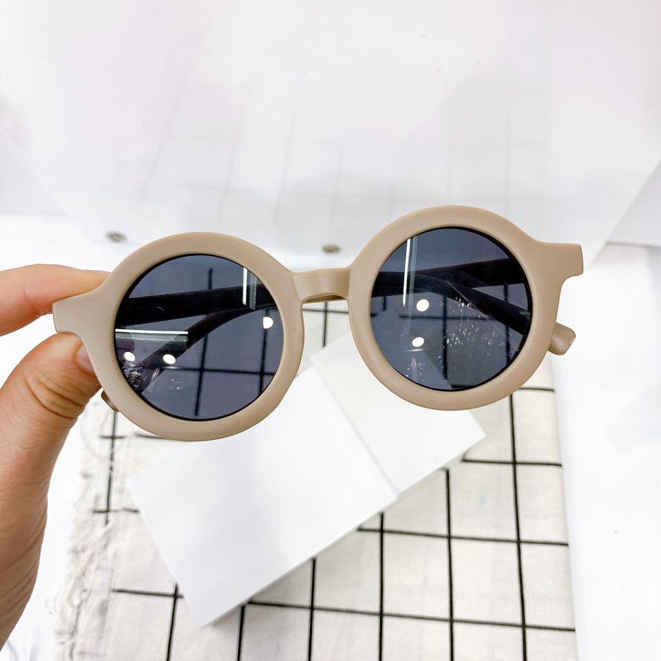 Round vintage style kids sunglasses by ozznekshoes with dark tinted lenses and colorful frame, perfect for playful outdoor looks.