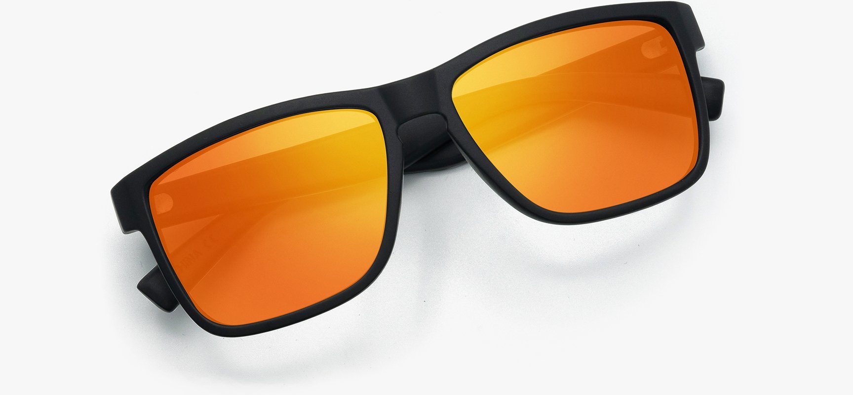 Sunglasses with orange lenses and black frames on a white background