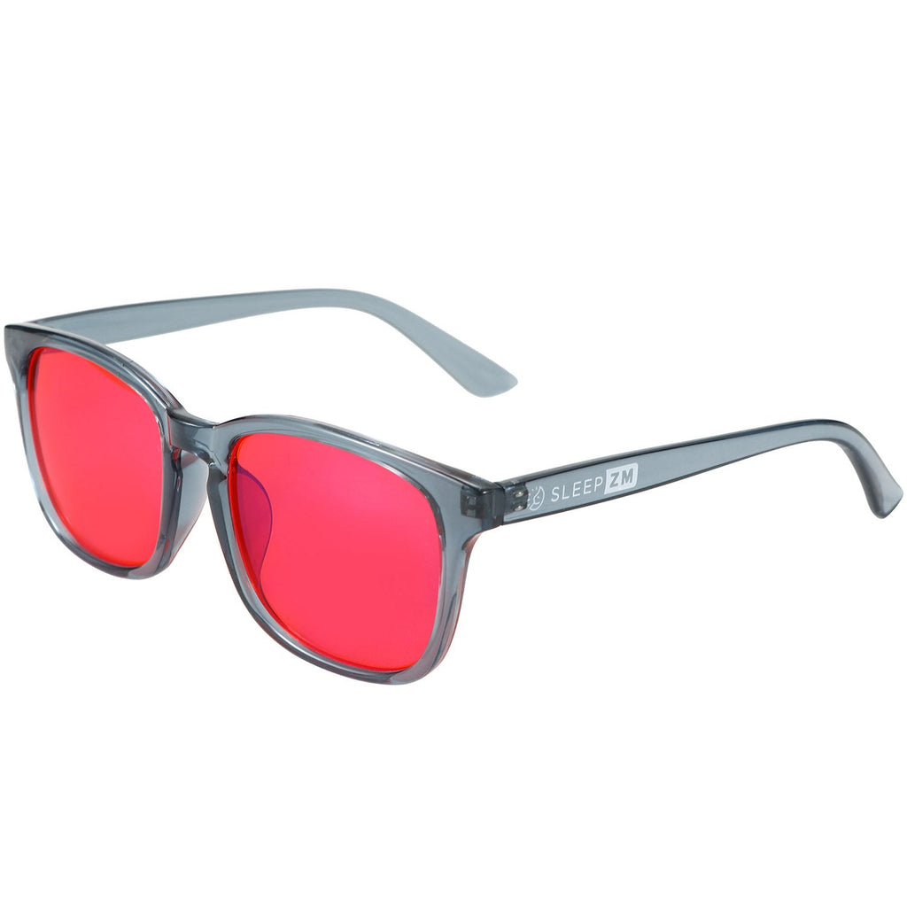 Blue Light Glasses by Sleep ZM with translucent blue frame and red tinted lenses, designed for night-time screen protection.