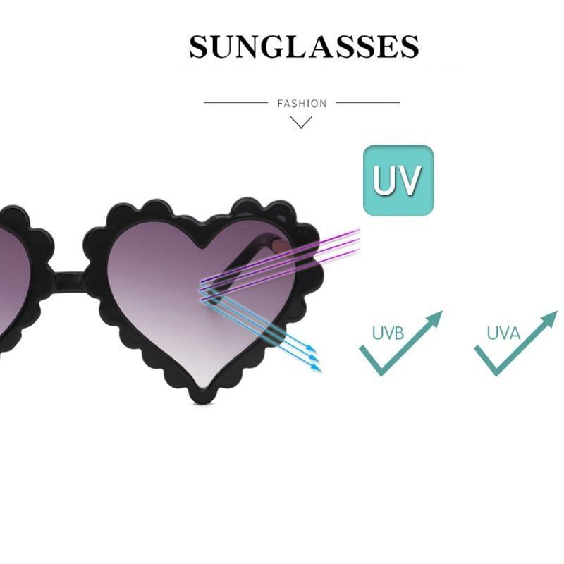 Kids' heart-shaped sunglasses by Stevvex with flower design, oversized frame, providing UV protection and a cute, fashionable look.