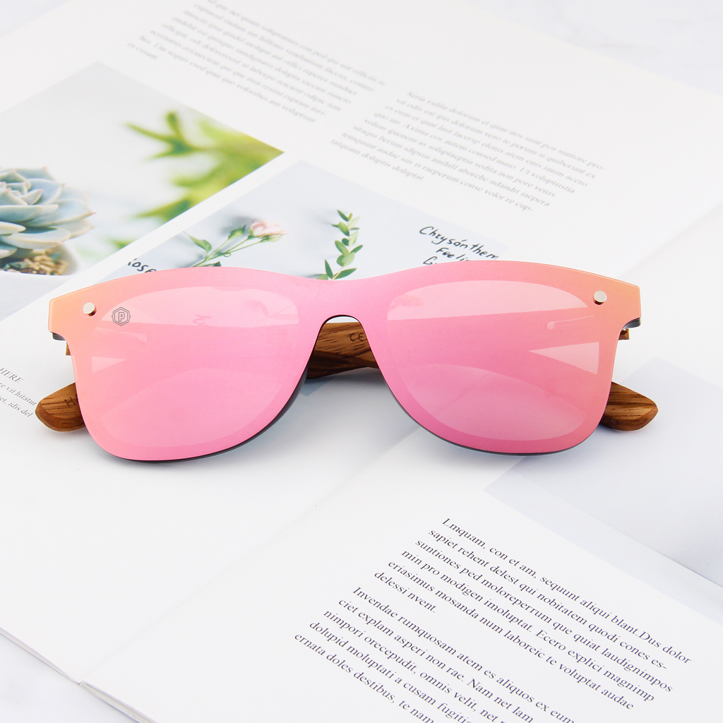 Papago Coral Ventures handmade recycled wooden sunglasses with newspaper-patterned frames, showcasing eco-friendly eyewear design.